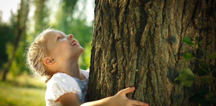 bambina che abbraccia un albero